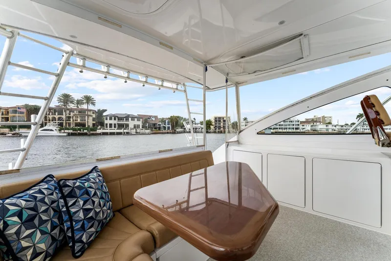 Slide: The Image of 2018 Viking 44 Express yacht interior with seating, table, and waterfront view. - 64