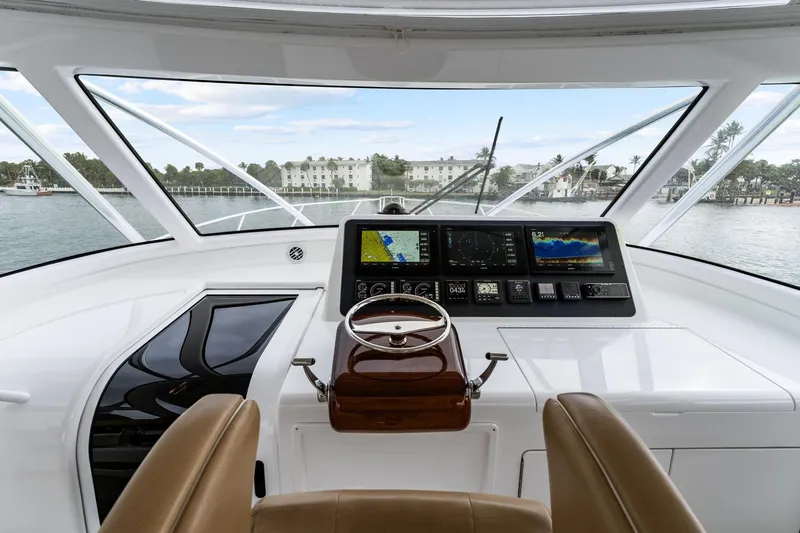 Slide: The Image of 2018 Viking 44 Express yacht helm with advanced navigation displays and leather seating. - 68