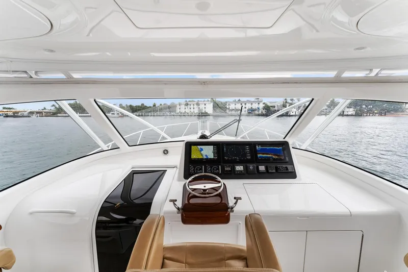 Slide: The Image of Cockpit view of 2018 Viking 44 Express yacht with navigation instruments and waterfront scenery. - 77