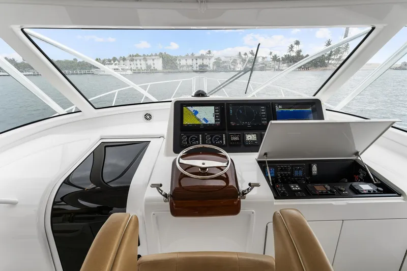 Slide: The Image of Cockpit of 2018 Viking 44 Express yacht with navigation instruments and steering wheel. - 81