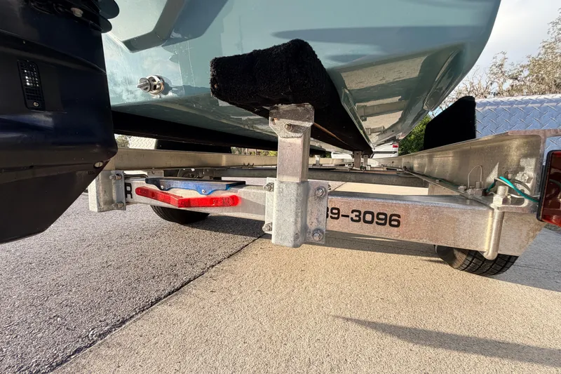 Slide: The Image of Trailer view of 2023 Dorado 16 Skiff boat, showcasing undercarriage and support structure. - 16