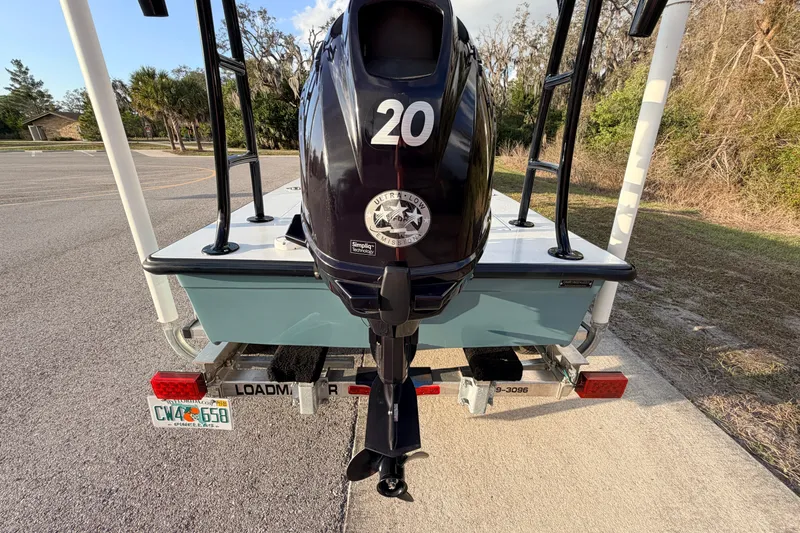 Slide: The Image of 2023 Dorado 16 Skiff boat on trailer with outboard motor, parked outdoors. - 18