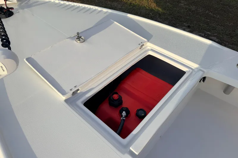 Slide: The Image of Open storage compartment on 2023 Dorado 16 Skiff boat, revealing red fuel tank. - 28