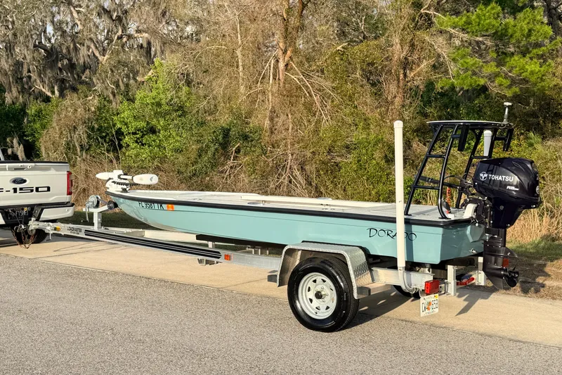 Slide: The Image of 2023 Dorado 16 Skiff boat on trailer, parked beside a Ford F-150 truck. - 3