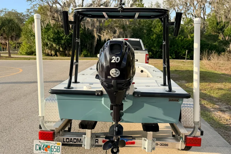 Slide: The Image of 2023 Dorado 16 Skiff on trailer with outboard motor, parked outdoors. - 4