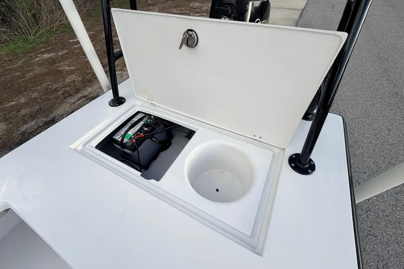 Slide: The Image of Open storage compartment on 2023 Dorado 16 Skiff boat, featuring battery and cup holder. - 41