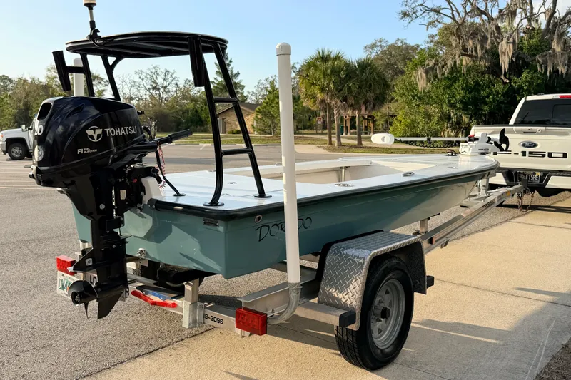 Slide: The Image of 2023 Dorado 16 Skiff boat on trailer with Tohatsu engine, parked outdoors. - 5