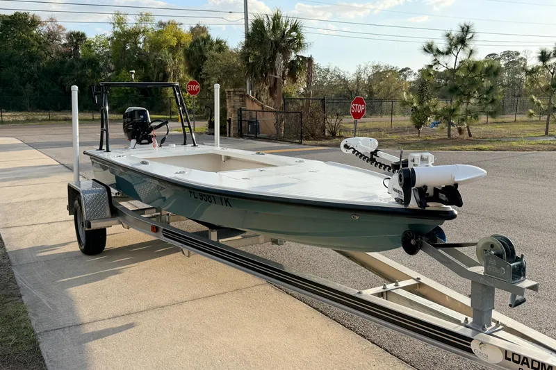 Slide: The Image of 2023 Dorado 16 Skiff boat on trailer, parked near road with stop signs. - 6