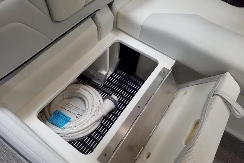 Slide: The Image of 2020 Formula 310 Bowrider OB storage compartment with coiled hose inside. - 8