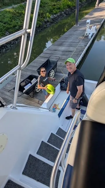 Slide: The Image of Two people on a 1998 Mainship Sedan Bridge boat at the dock. - 12