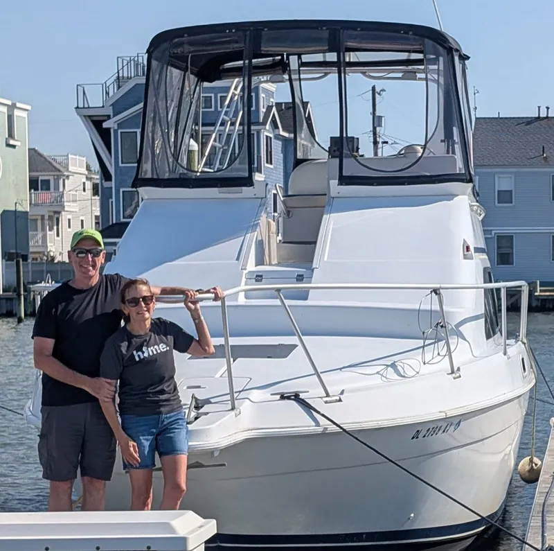 Slide: The Image of Couple posing on 1998 Mainship Sedan Bridge yacht at dock. - 2