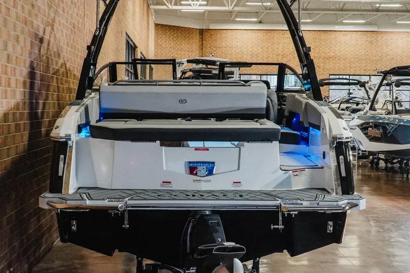 Slide: The Image of 2026 Cobalt R4 boat in showroom, rear view with seating and blue lighting. - 6