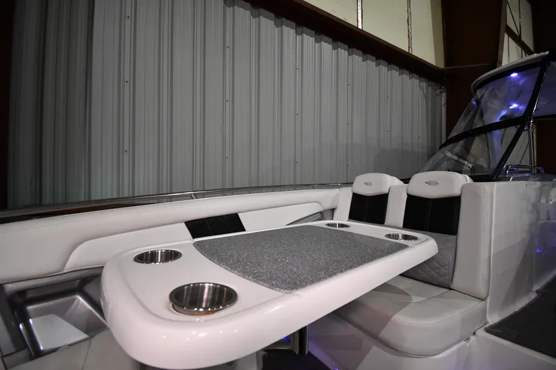 Slide: The Image of 2014 Chaparral 327 SSX boat interior with seating and table, featuring cup holders. - 20