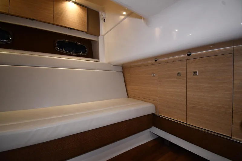 Slide: The Image of Interior of 2014 Chaparral 327 SSX boat with wood cabinets and cushioned seating. - 26