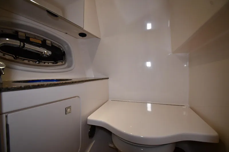 Slide: The Image of 2014 Chaparral 327 SSX boat bathroom with sleek white interior and compact design. - 28