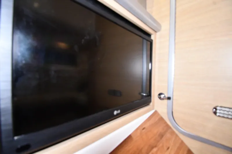 Slide: The Image of Interior view of a 2014 Chaparral 327 SSX featuring a mounted flat-screen TV. - 30