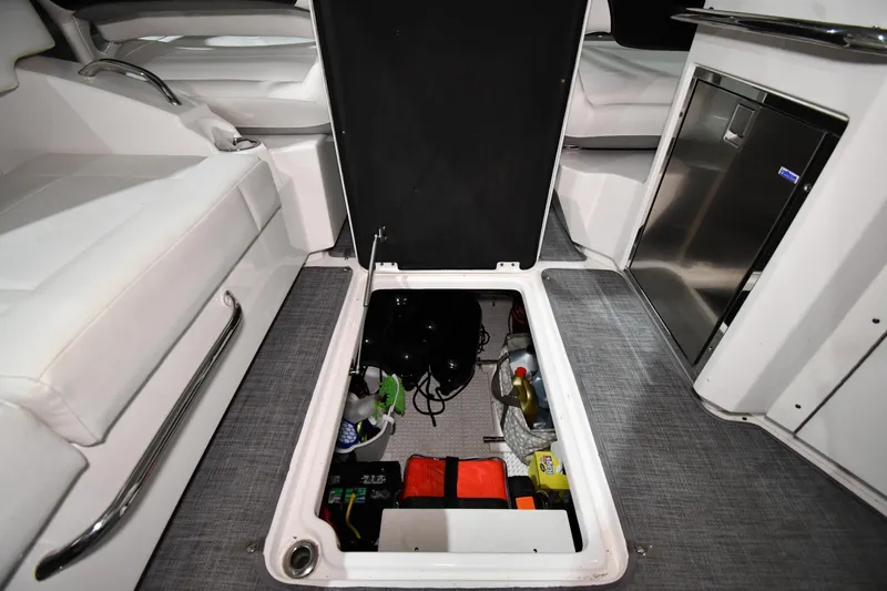 Slide: The Image of Storage compartment in 2014 Chaparral 327 SSX boat, featuring organized equipment and supplies. - 39