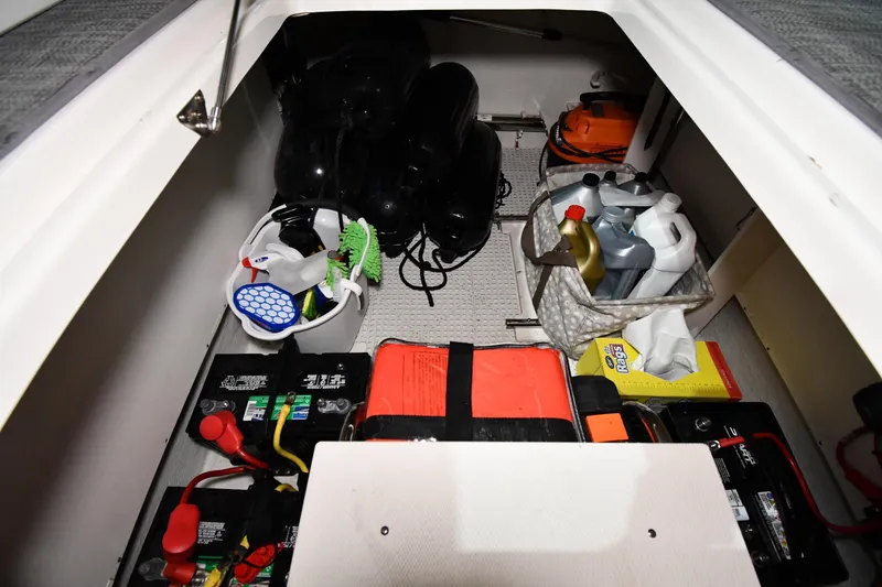 Slide: The Image of Storage compartment of 2014 Chaparral 327 SSX boat with cleaning supplies and batteries. - 40