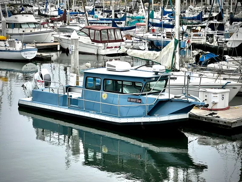 The Image of Blue ACB 30 boat docked in a marina, surrounded by various sailboats. - 0