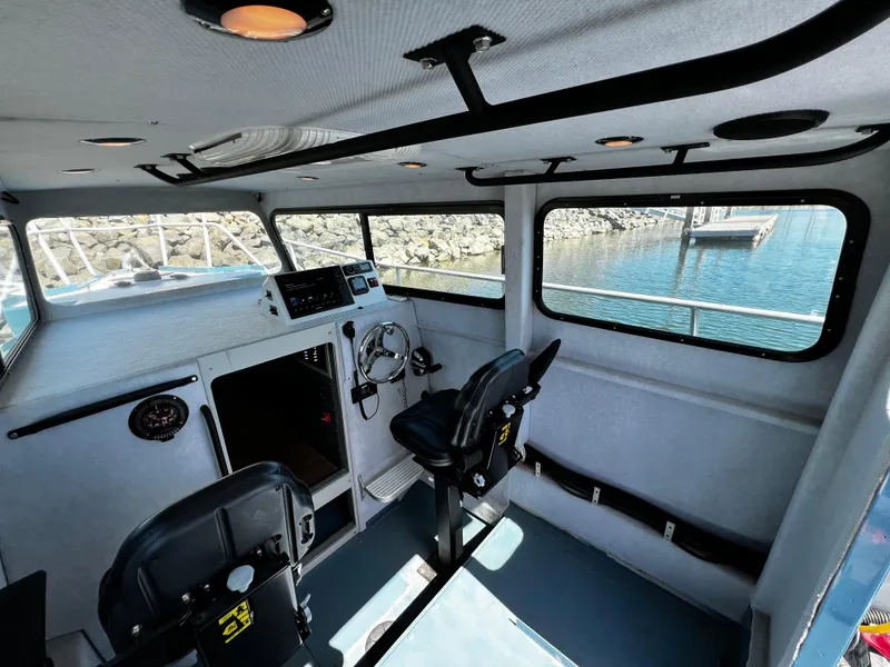 Slide: The Image of Interior of 2003 ACB 30 boat with steering wheel and seating, dockside view. - 20