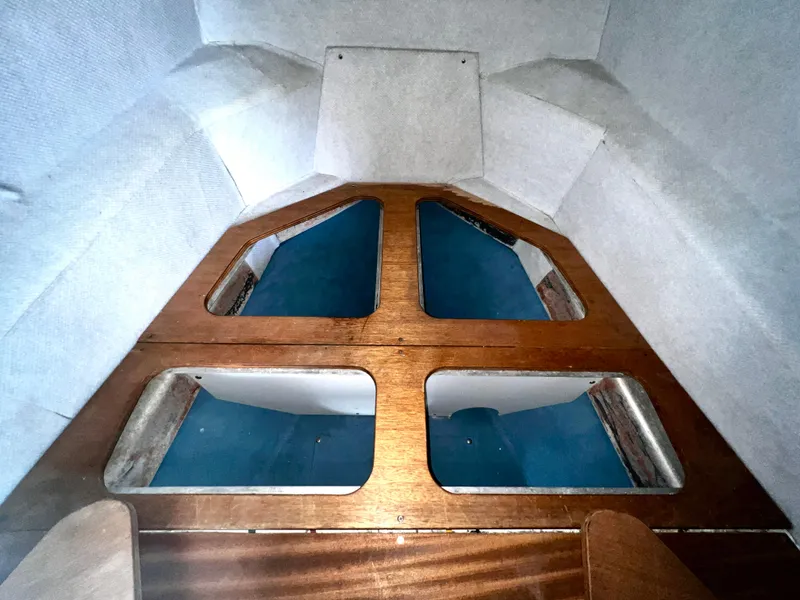 Slide: The Image of Interior view of ACB 30 boat cabin, featuring wooden panels and blue accents, 2003 model. - 28