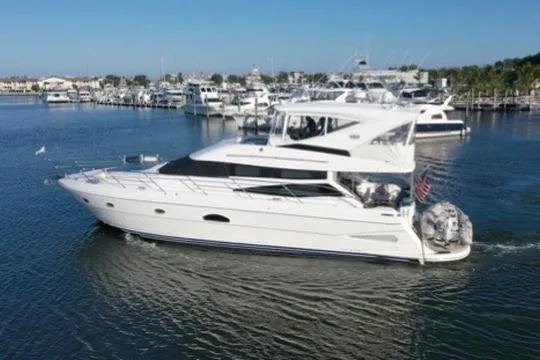 Slide: The Image of 2005 Neptunus 56 Flybridge yacht cruising in a marina, surrounded by other boats. - 11