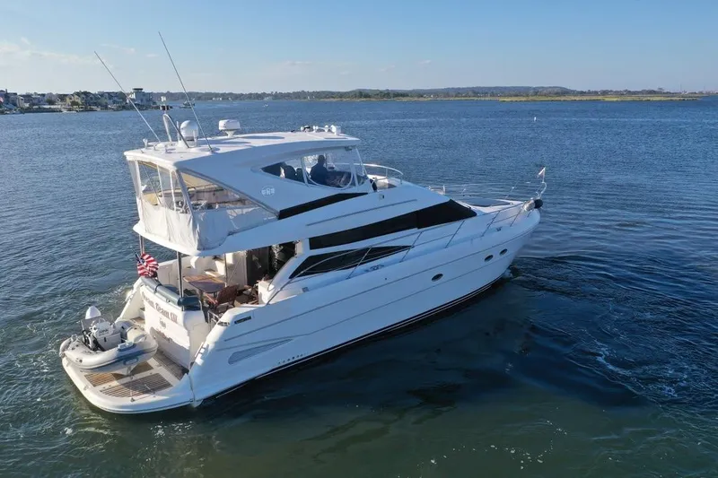 Slide: The Image of 2005 Neptunus 56 Flybridge yacht cruising on a serene blue waterway. - 2
