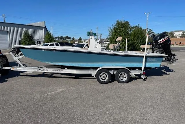 The Image of 2017 Intruder 23 boat on trailer with Suzuki outboard motor in parking lot. - 0