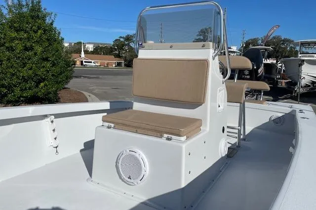 Slide: The Image of 2017 Intruder 23 boat with beige seating and console, parked outdoors. - 5