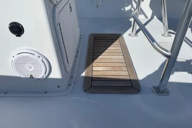 Slide: The Image of 2017 Intruder 23 boat deck with wooden step and metal railing. - 7