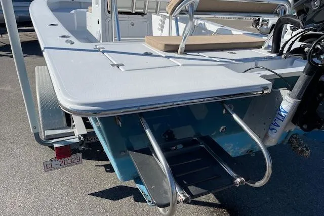 Slide: The Image of 2017 Intruder 23 boat stern with ladder and seating, parked on a trailer. - 9