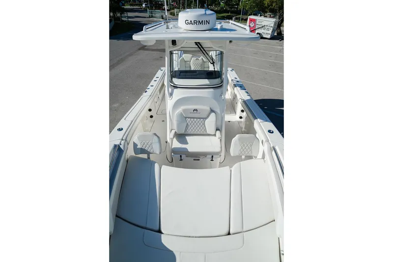 Slide: The Image of 2024 World Cat 295 CC boat interior with Garmin equipment, featuring white seating and console. - 25