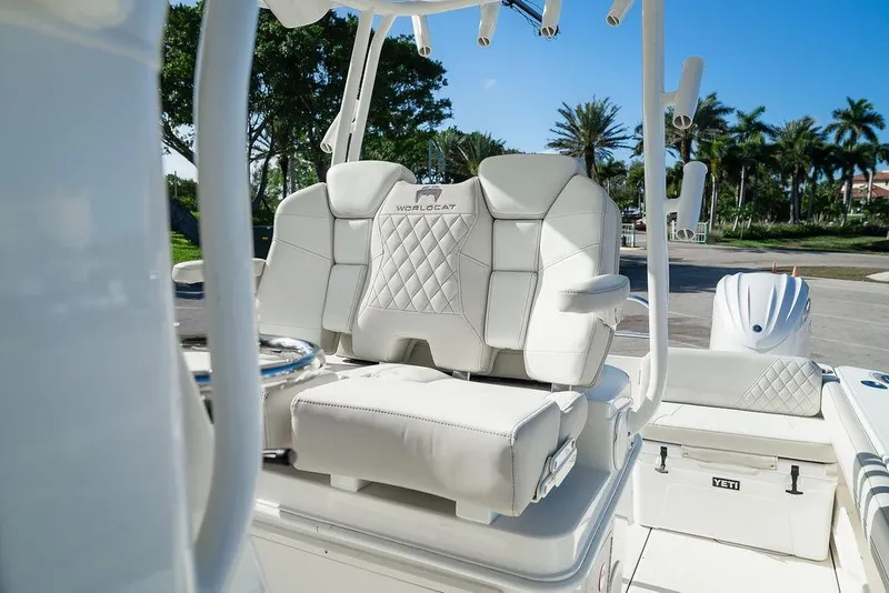 Slide: The Image of 2024 World Cat 295 CC boat with luxurious white seating and palm trees in the background. - 31