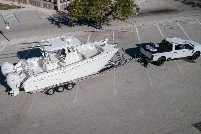 Slide: The Image of 2024 World Cat 295 CC boat on trailer, towed by a white truck in parking lot. - 41