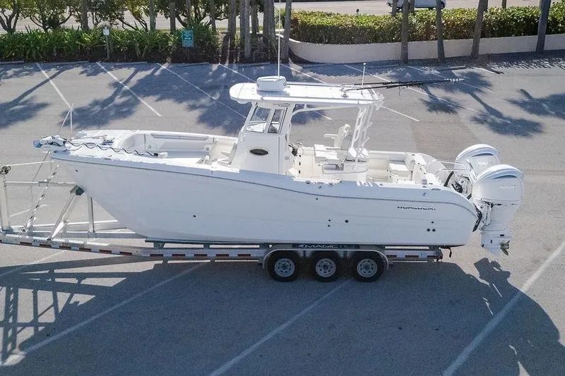 Slide: The Image of 2024 World Cat 295 CC boat on trailer in parking lot, side view. - 43