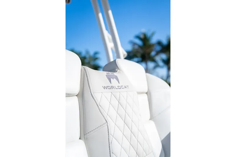 Slide: The Image of 2024 World Cat 295 CC boat seat with logo, palm trees in background. - 47