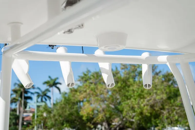 Slide: The Image of Rod holders on a 2024 World Cat 295 CC boat against a clear blue sky. - 51