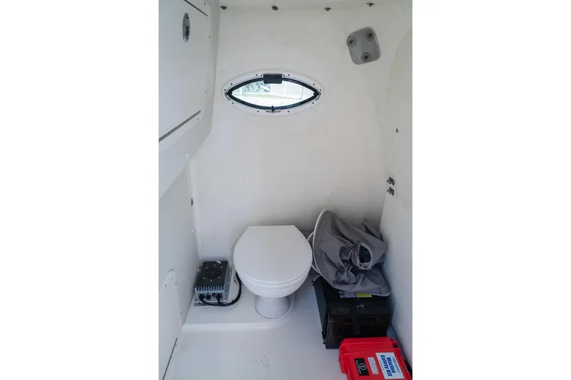 Slide: The Image of Interior of 2024 World Cat 295 CC boat featuring a compact marine toilet. - 61