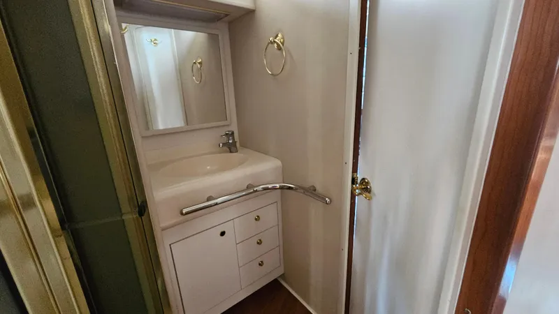 Slide: The Image of Bathroom vanity in 1999 Sea Ray 500 Sundancer yacht, featuring sink, mirror, and storage. - 34