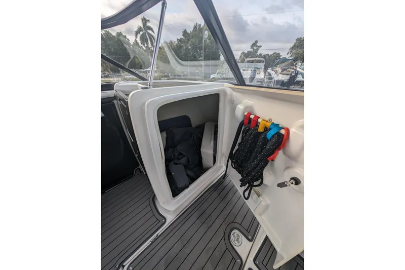 Slide: The Image of 2014 Yamaha Boats 242 Limited S storage compartment with ropes and gear. - 10