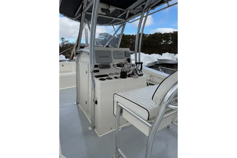 Slide: The Image of 2014 AmeraCat 27 boat console with Garmin and Fusion equipment, featuring a cushioned seat. - 4
