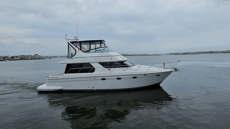 Slide: The Image of 2000 Carver 450 Voyager Pilothouse yacht cruising on calm waters. - 10