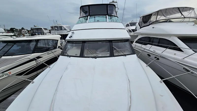 Slide: The Image of 2000 Carver 450 Voyager Pilothouse yacht docked among other boats. - 16