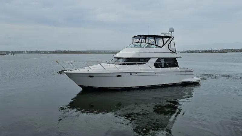 Slide: The Image of 2000 Carver 450 Voyager Pilothouse yacht on calm water, overcast sky. - 2