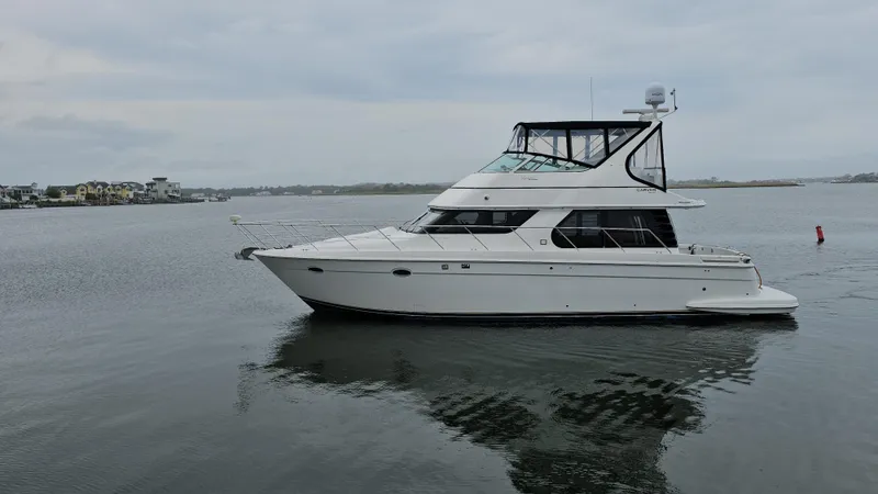 Slide: The Image of 2000 Carver 450 Voyager Pilothouse yacht on calm water, overcast sky. - 6