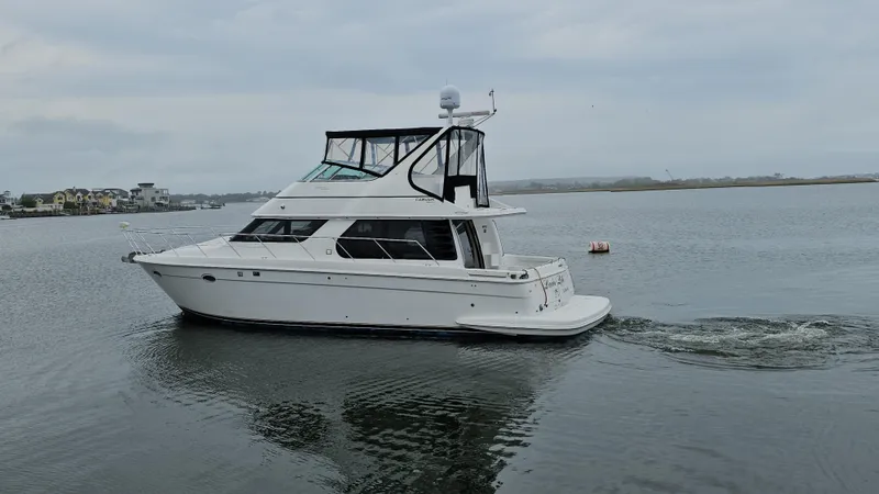 Slide: The Image of 2000 Carver 450 Voyager Pilothouse yacht cruising on calm waters. - 7