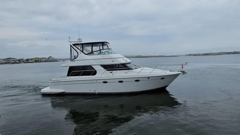 Slide: The Image of 2000 Carver 450 Voyager Pilothouse yacht cruising on calm waters. - 8