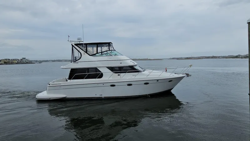 Slide: The Image of 2000 Carver 450 Voyager Pilothouse yacht cruising on calm waters. - 9