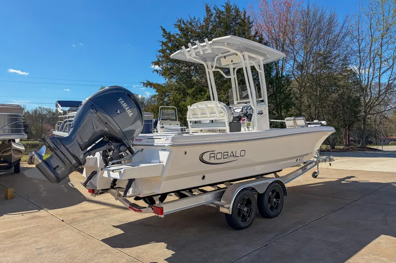 The Image of 2025 Robalo 226 Cayman boat on trailer with Yamaha outboard motor, parked outdoors. - 1