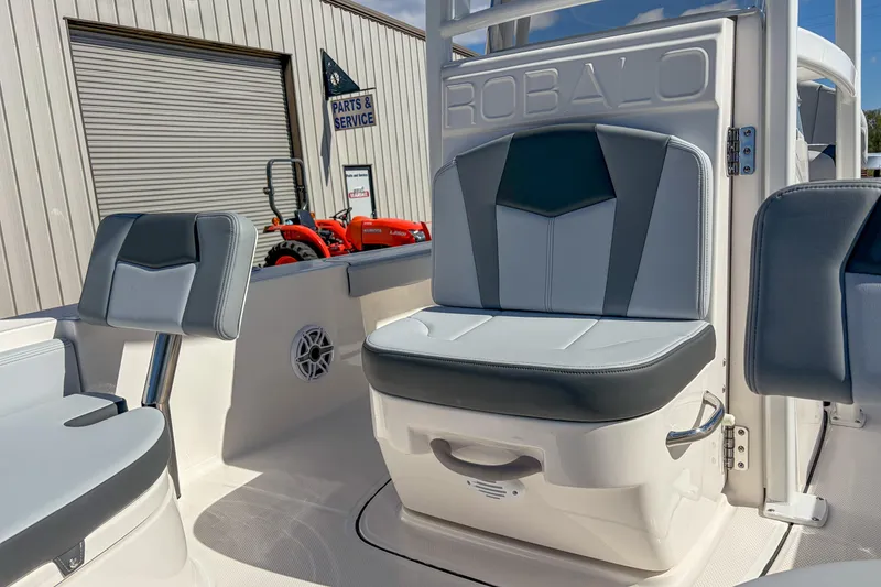 Slide: The Image of 2025 Robalo 226 Cayman boat interior with gray seating and parts service sign. - 12